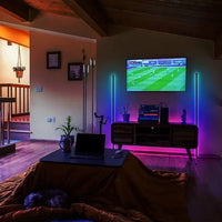 Corner floor lamp with RGB LEDs showing multi-color illumination against a white wall.