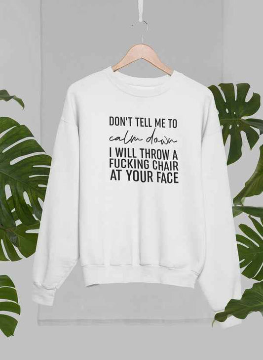 Grey crewneck sweatshirt hanging on a hanger with a palm tree background