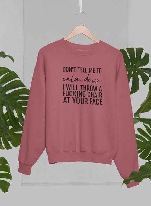 Close-up of grey sweatshirt hanging with palm trees in the background