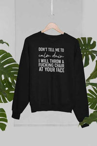 Grey sweatshirt hanging on wood hanger against a palm tree background