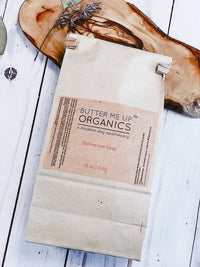 Measuring spoon filled with all natural dishwasher soap powder over wooden background