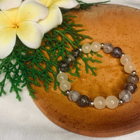 Detailed view of smooth gray and white agate beads with polished silver spacers.