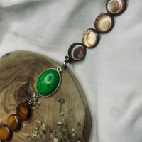 Stylish natural stone bracelet with distinctive green turquoise and brown beads displayed.