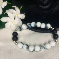 Close-up of Howlite and Black Onyx stretch bracelet with silver spacers showing natural bead textures.