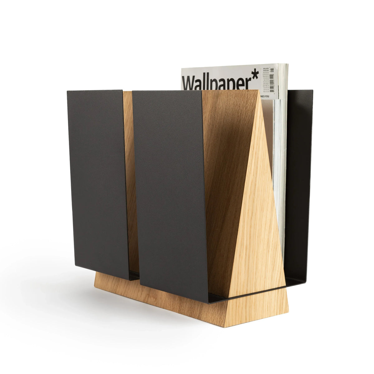 Standing magazine holder WINGS in oak wood and black metal with magazines arranged inside on a wooden floor.
