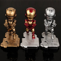 Iron Man phone stand beside a smartphone and desktop items illustrating desktop organization.
