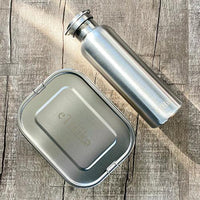 Stainless steel lunchbox with flexible divider showing compartments for different foods.