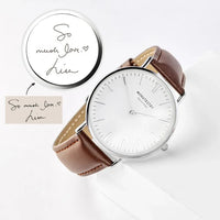 Close-up of copper dial on men’s watch featuring minimalist design and metallic hands.
