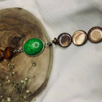Top view of green turquoise and brown bead bracelet displayed on white background.