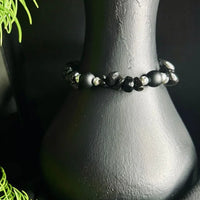 Detailed view of natural black stone chips forming a stretch cord bracelet.