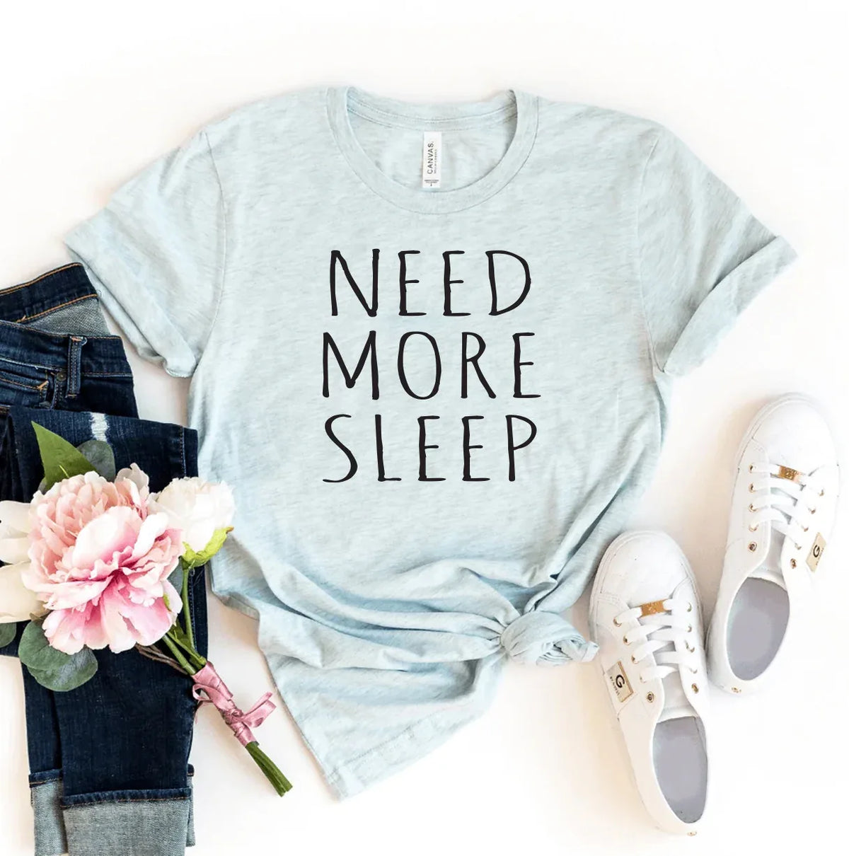 Front view of a white T-shirt featuring 'Need More Sleep' text in bold black letters.