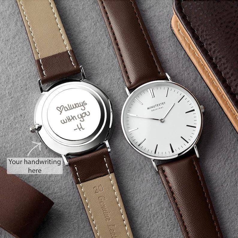 Close-up of men's wristwatch with copper dial and genuine leather band on a wooden surface.