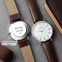 Close-up of men's wristwatch with copper dial and genuine leather band on a wooden surface.