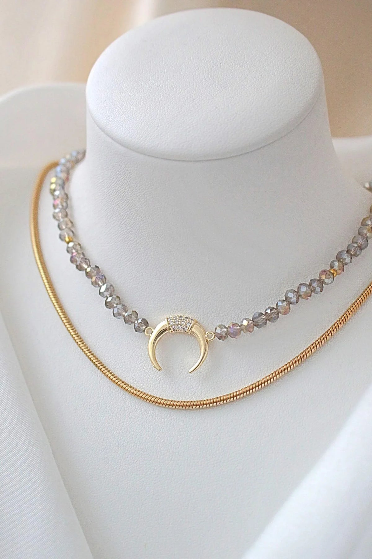 Close-up of light blue chrome Austrian crystal choker with sparkling surface and gold-plated charm pendant.