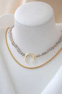 Close-up of light blue chrome Austrian crystal choker with sparkling surface and gold-plated charm pendant.