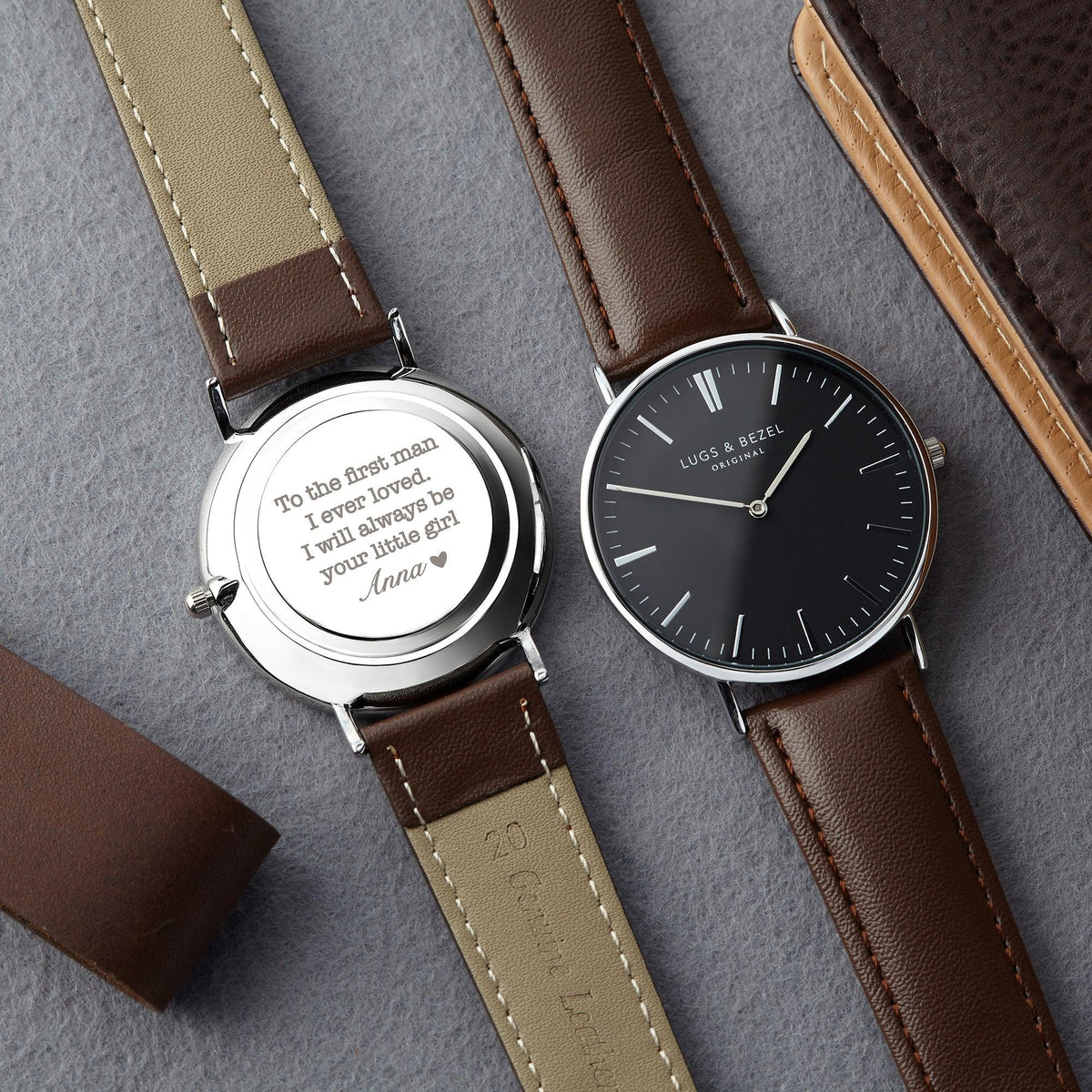 Men's watch with shiny stainless steel case and genuine leather strap displayed flat.