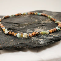 Multi-color natural agate stone necklace laid out to highlight varied bead shapes and colors.