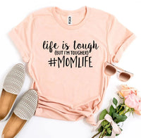 Back view of white #Momlife T-shirt on wooden surface
