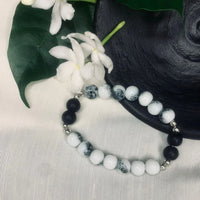 Side angle of stretch bracelet combining natural white howlite and smooth black onyx beads.