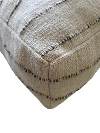 Nomad Floor Cushion displayed on wooden floor showcasing natural colors and soft foam filling.