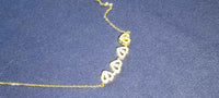 Four-leaf clover and heart shape necklace displayed on white, highlighting polished silver finish.