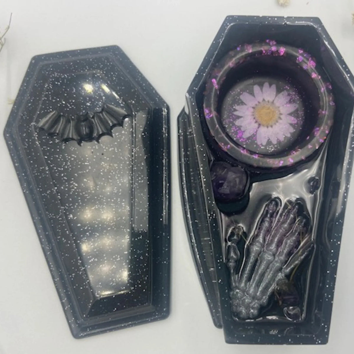 Handcrafted black resin coffin candle holder featuring amethyst stones, dried flowers, and central hole for incense.