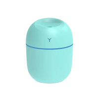 Close-up of white ultrasonic essential oil diffuser showing mist and illuminated LED glow.