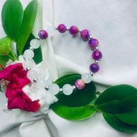 Elegant bracelet featuring alternating white and purple stones with shiny silver spacers.