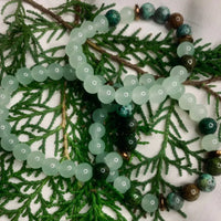 Elegant green and white agate bracelet featuring copper spacer beads against plain backdrop
