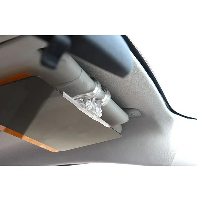 A car driver uses a transparent anti-dazzle visor to block sunlight and glare from oncoming headlights.