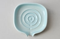 Soap dish holding a bar of soap on a clean bathroom sink area.