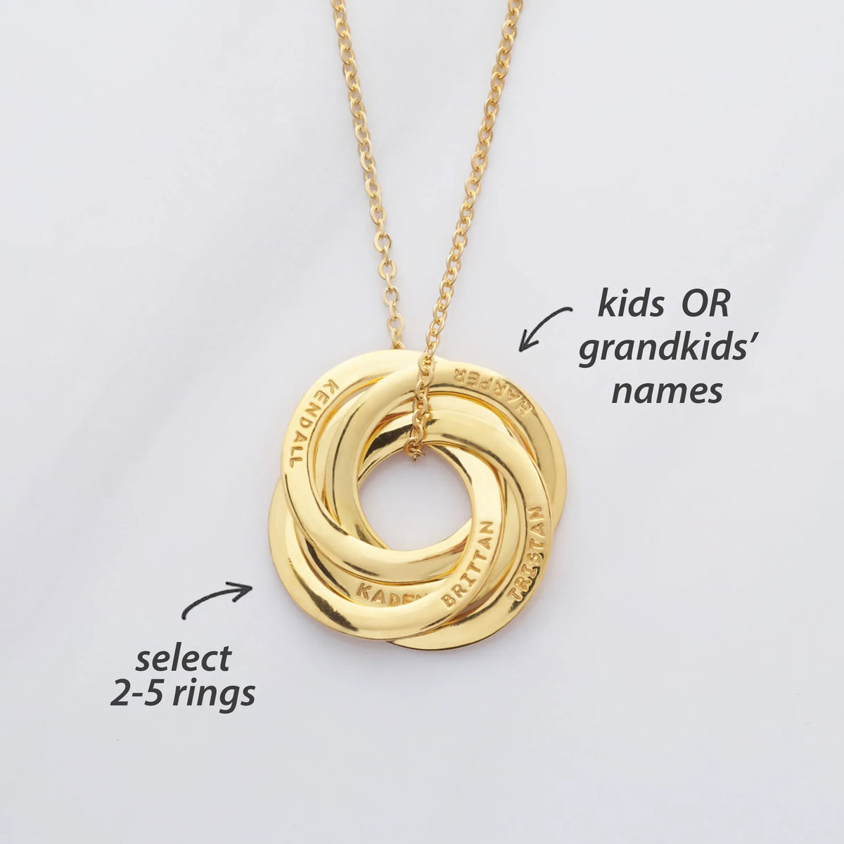 Silver interlocking rings necklace displayed on a white background, showing multiple polished circular pendants.