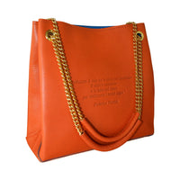 Burgundy Loving Handbag with engraved poem on leather surface and shiny adjustable handles, styled elegantly.
