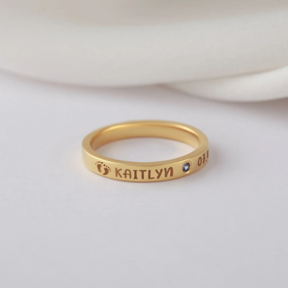 Close-up view of a silver ring with custom engravings, ideal as a new mom gift.