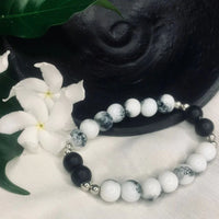 Detailed view of black onyx and howlite beads with shiny silver spacers forming a stretchy bracelet.