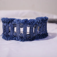 Close-up of denim tribal bracelet with lava and agate stones showing detailed stitching and texture.