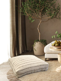Top view of Nomad Floor Cushion showing natural linen and jute fabric with 3D stripes.
