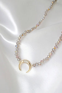 Light blue chrome Austrian crystal choker necklace laid flat highlighting crystals and gold charm pendant.