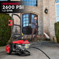 User holding pressure washer wand spraying water on a driveway for cleaning.