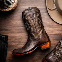 Close-up of western-style Denver boot with rich red vamp and black leather shaft outdoors.