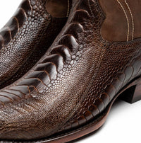 Artistic angled photo of Denver Clear Brown ostrich leg skin cowboy boot displaying fine leather grain.
