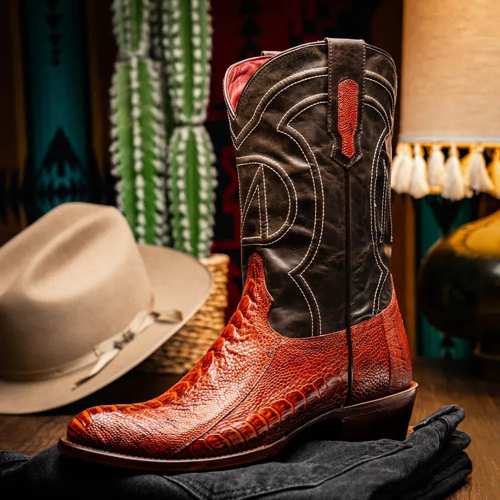 Person standing on rustic floor wearing Denver Rustic Cognac ostrich skin cowboy boots.