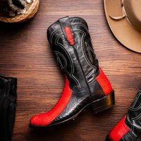 Lifestyle image of Denver red and black ostrich leg cowboy boots on feet.