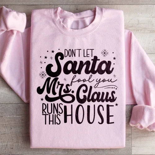 Light pink sweatshirt featuring 'Don't Let Santa Fool You Mrs Claus Run This House' graphic