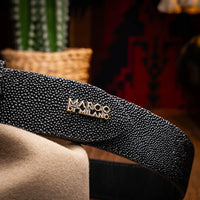 Close-up of black stingray belt worn around waist with jeans and white shirt