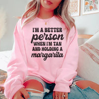 Light pink T-shirt with the printed phrase 'I'm A Better Person When I'm Tan And Holding A Margarita' in peach.