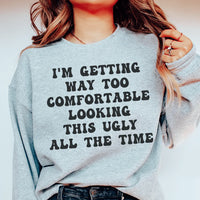 Sport grey sweatshirt with phrase 'I'm Getting Way Too Comfortable Looking This Ugly All The Time' in white and pink text.