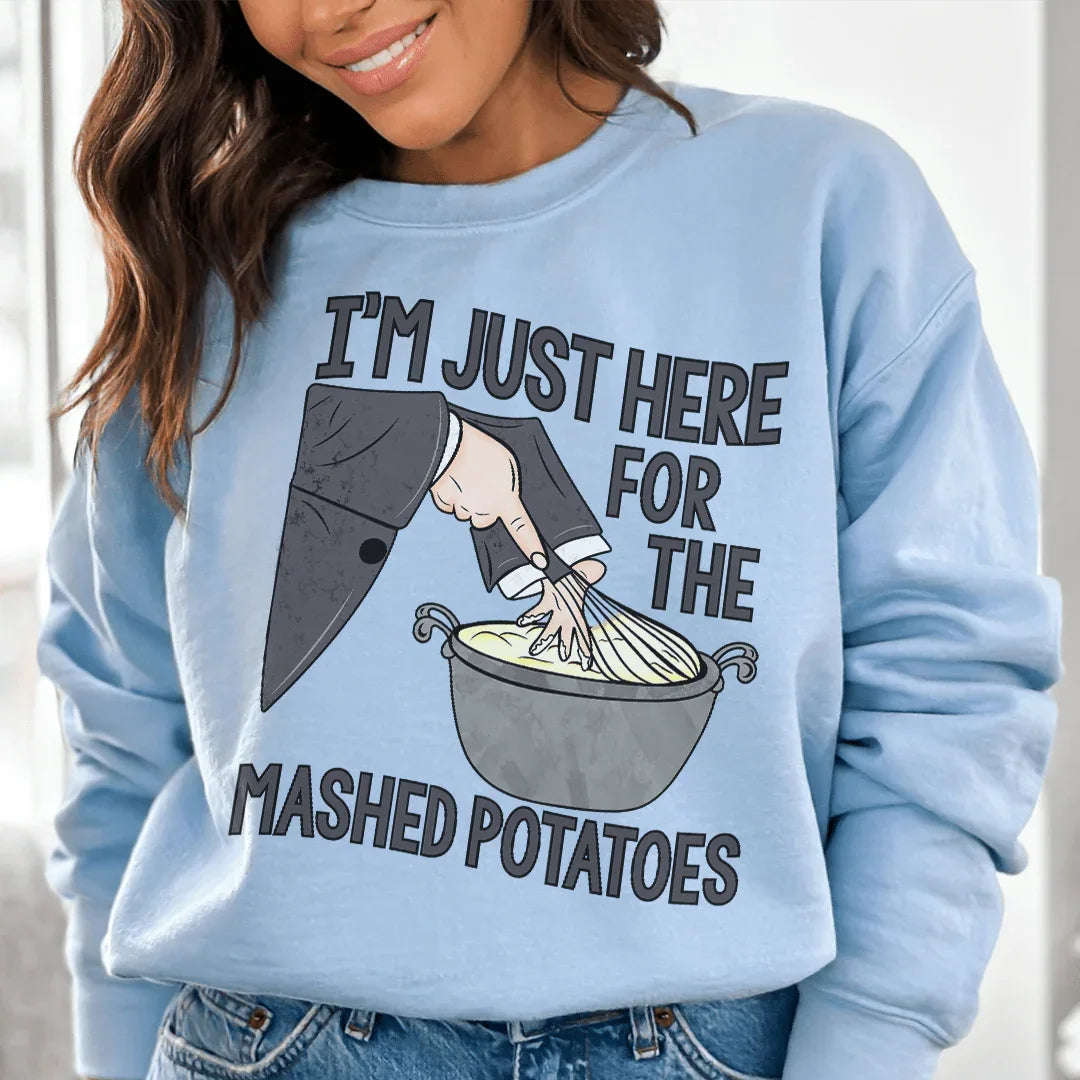 Light blue sweatshirt with 'I'm Just Here For The Mashed Potatoes' text in white and orange lettering.