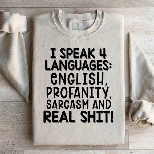 Front view of peach sweatshirt featuring the bold phrase I Speak Four Languages.