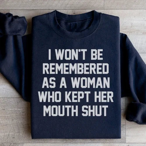 Black sweatshirt showing the phrase 'I Won't Be Remembered As A Woman Who Kept Her Mouth Shut' in white font.